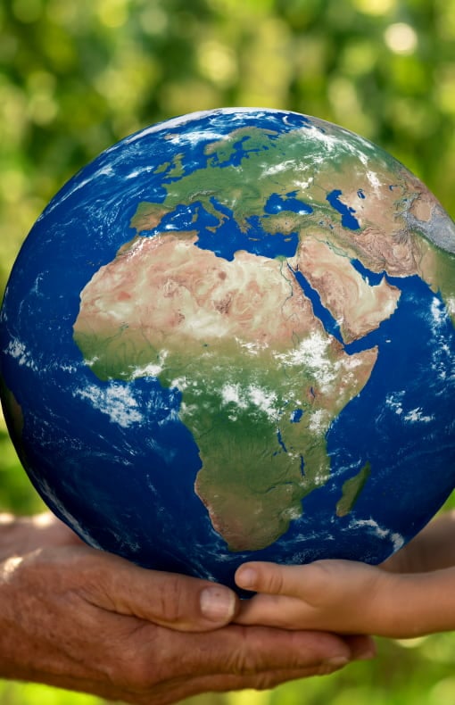 Two hands gently holding a globe, symbolizing global unity and care for the planet.