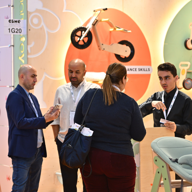 An overhead view of the hall with exhibitor stands and visitors exploring products and chatting.