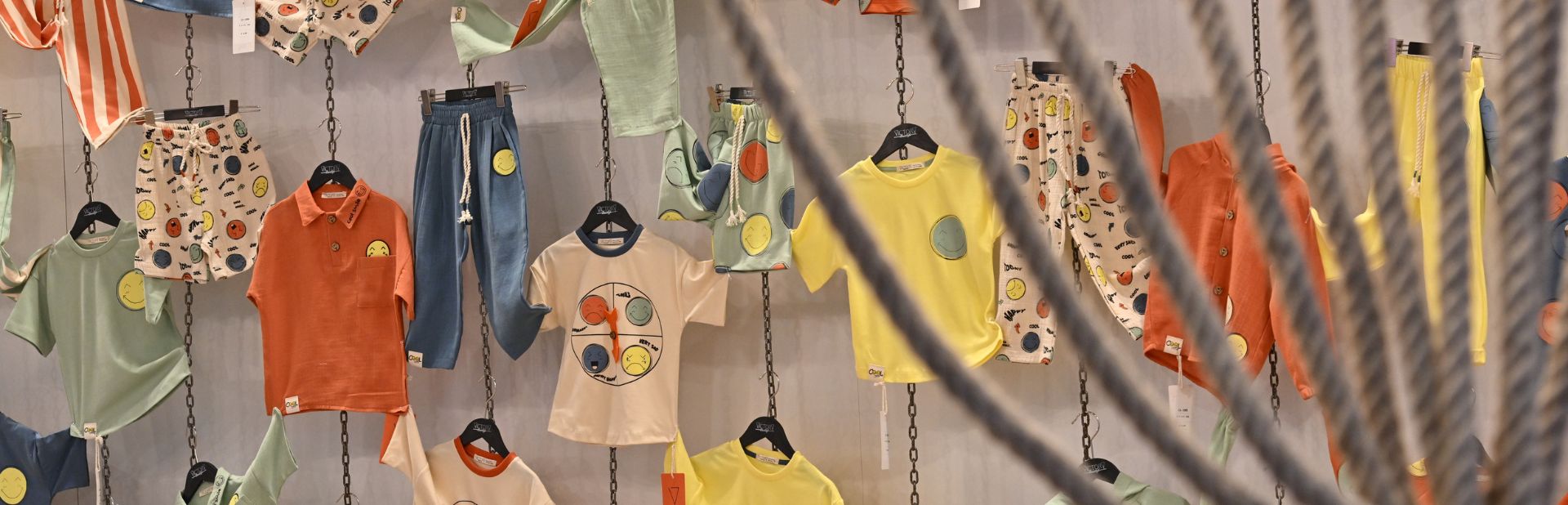 colorful children's clothes hanging on the wall at the CBME Türkiye exhibition.