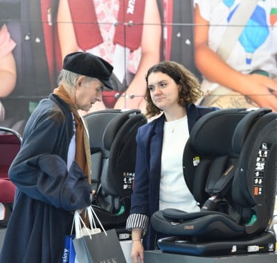An exhibitor showing a baby carriage product to her customer.