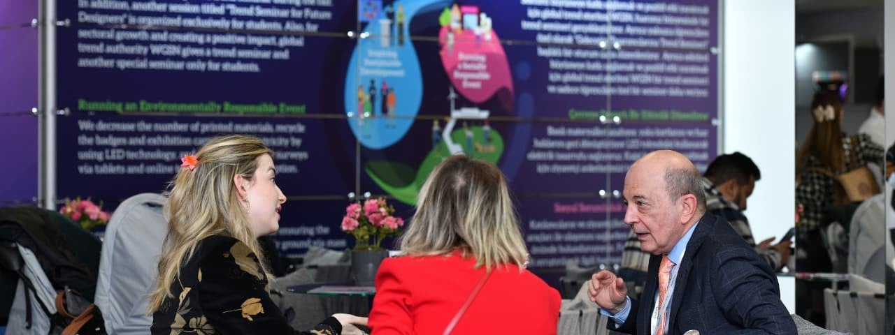 Three attendees seated at a table at CMBE Turkey, engaged in conversation