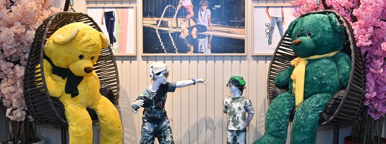 Two manequins and plush bears infront of a wall at CBME Türkiye 2024