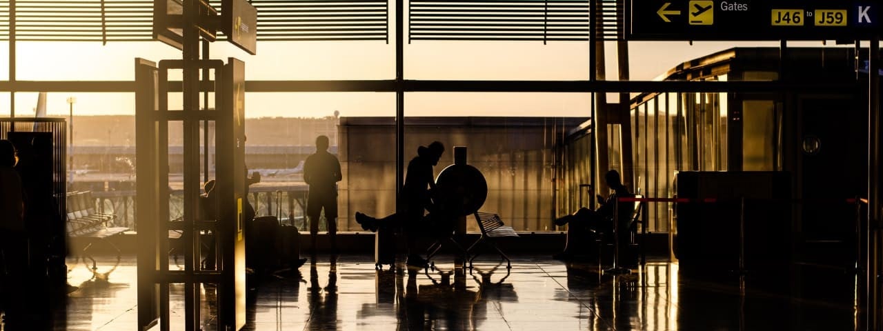 Sunset at the airport with people waiting for their plane.
