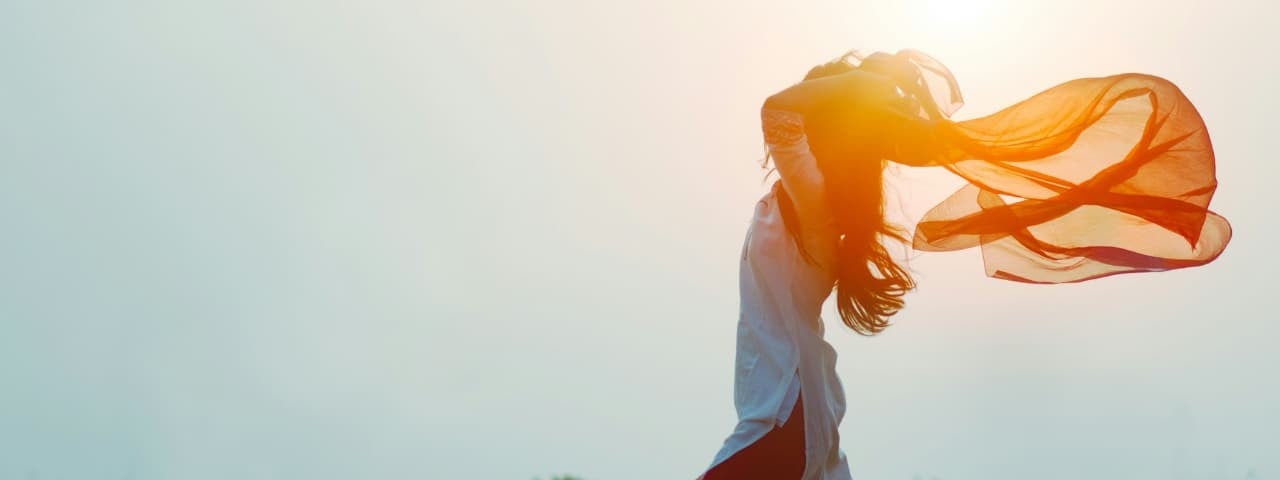 A woman running, making a scarf flutter in the wind.