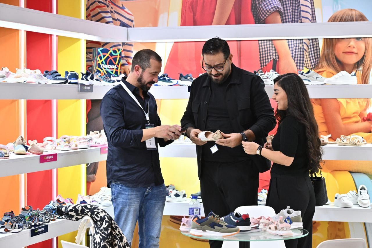 An exhibitor showing a baby carriage product to her customer.